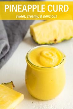 pineapple curd in a small jar next to slices of pineapple on a white surface