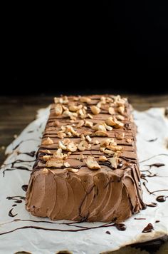 a cake with chocolate frosting and nuts on top