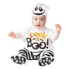 a baby dressed in a costume sitting on the ground with his hands up and eyes wide open