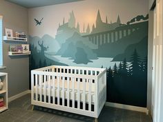 a baby's room with a large mural on the wall and a white crib