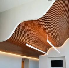 an empty room with wooden ceiling and white walls