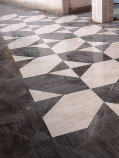 a black and white tiled floor next to a building