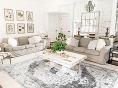 a living room with couches, chairs and a rug on the floor in front of them