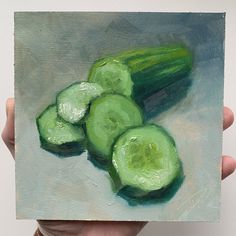 a painting of cucumbers is being held up