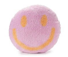 a pink and yellow smiley face pillow on a white background