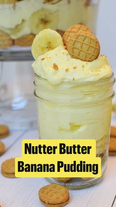 a dessert in a glass jar with cookies and crackers on the table next to it