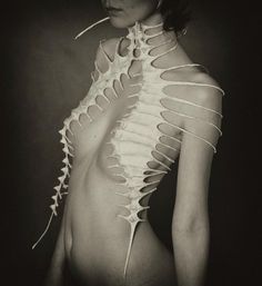 the woman is posing with her back to the camera and skeleton parts on her body