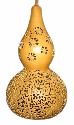 a gold vase with an intricate design on the top and bottom, sitting in front of a white background