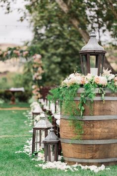 a wooden barrel filled with flowers and greenery sitting on top of a lush green field