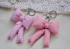 two pink bows are attached to key chains