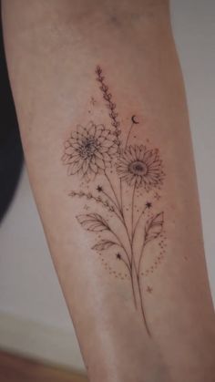 a woman's leg with flowers and stars tattoo on the side of her calf