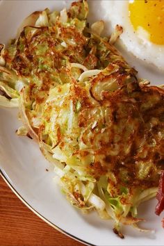 an egg is on top of some cabbage and hashbrowns are on the plate