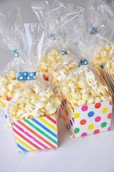 three bags of popcorn sitting next to each other on top of a table with polka dots