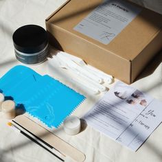 an assortment of crafting supplies sitting on a table next to a box and scissors