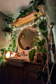 a bathroom with plants on the wall and lights in the mirror over the sink area