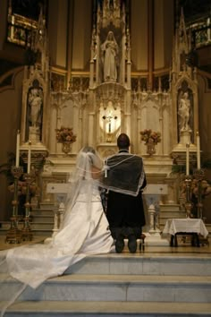 the bride and groom are sitting at the alter