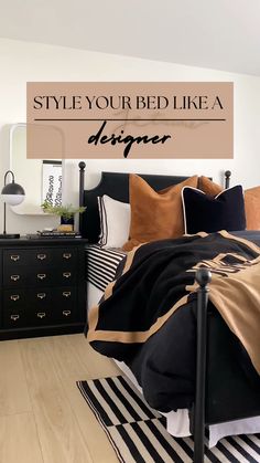 a bedroom with black and white striped bedspread, gold throw pillows, and an oversized sign that says style your bed like a designer