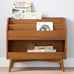 a wooden shelf with books and magazines on it