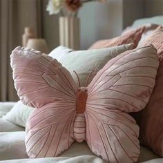 a pink butterfly pillow sitting on top of a bed