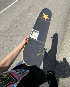 a person holding up a skateboard in the street