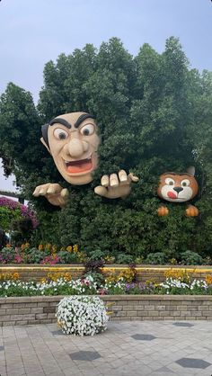 an inflatable face and two heads on display at the entrance to disney's animal kingdom