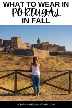 a woman standing in front of a fence with the words what to wear in portugal in fall