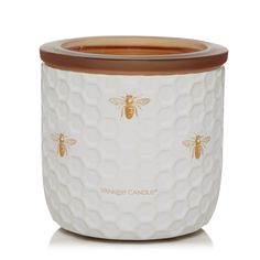 a white and brown jar with a bee on it