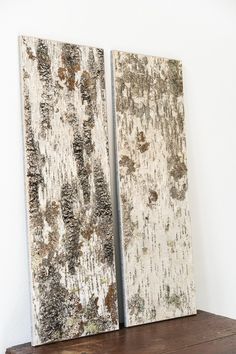 two pieces of wood sitting on top of a wooden shelf in front of a white wall