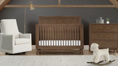 a baby's room with a rocking chair, crib and dresser in it