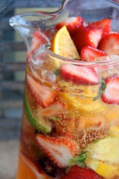 a pitcher filled with fruit sitting on top of a table