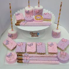 a cake and cupcakes on a table with pink frosting, gold trimmings