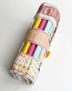 a roll of fabric with different colors and designs on the inside is sitting on a white surface