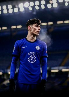 a soccer player is standing in front of an empty stadium with his hands on his hips