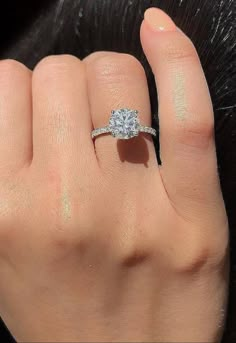 a woman's hand with a diamond ring on it