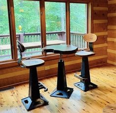 three office chairs sitting in front of a window on top of a hard wood floor