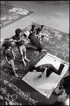 a group of young people standing on top of a skateboard ramp covered in graffiti