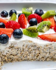 a close up of a plate of food with berries and kiwis on it