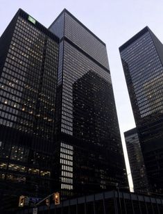 two very tall buildings in the city at dusk