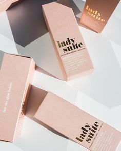 three pink boxes sitting on top of a white table next to each other with the words lady suite written on them