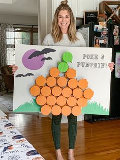 a woman holding up a sign with pumpkins on it