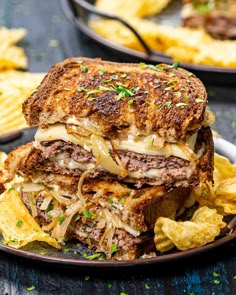 two plates with sandwiches and chips on them, one is cut in half to show the meat