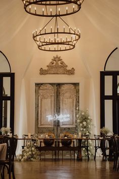 an elegant wedding reception setup with chandelier and table setting in front of the doors