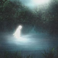 a person standing in the middle of a body of water under a light that is shining