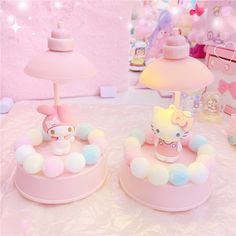 two hello kitty lamps sitting on top of a table next to a pink lamp shade