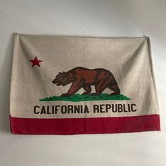 a flag hanging on the wall that says california republic with a grizzly bear and red star