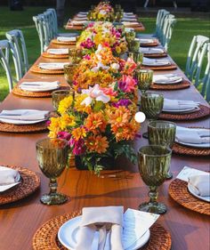 the table is set with plates and place settings for an outdoor dinner party or celebration