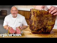 a man standing next to a large piece of meat on top of a wooden cutting board