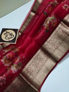 a red and gold silk saree with flowers on it