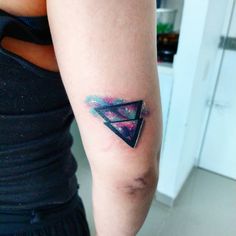 a woman's arm with a tattoo on it that has an image of a triangle