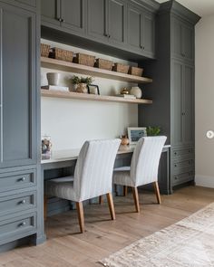 a dining room with gray cabinets and white chairs